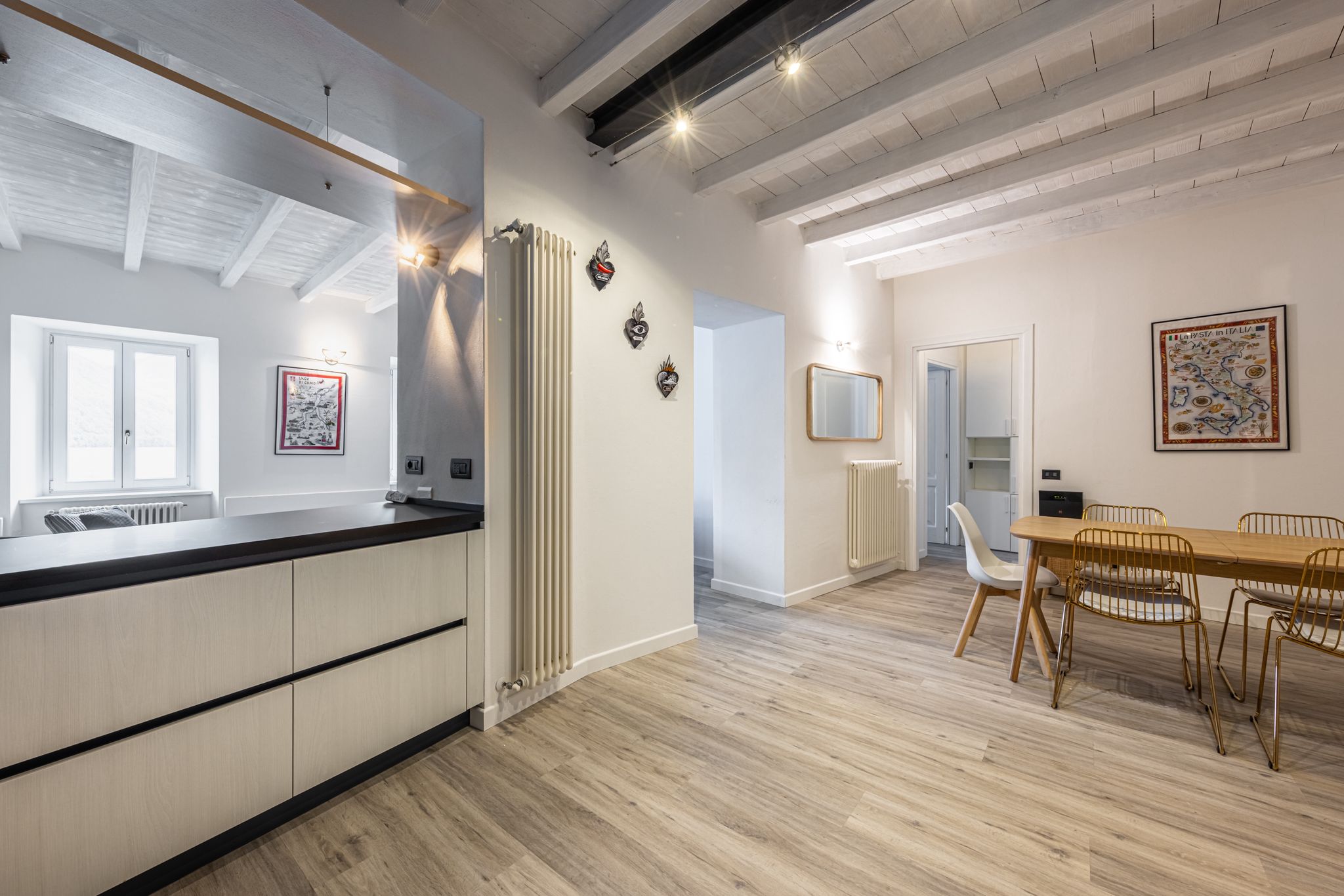 Aqua Vista di Splendore — open-space sala da pranzo e cucina, soffitto a travi bianche e parquet rovere