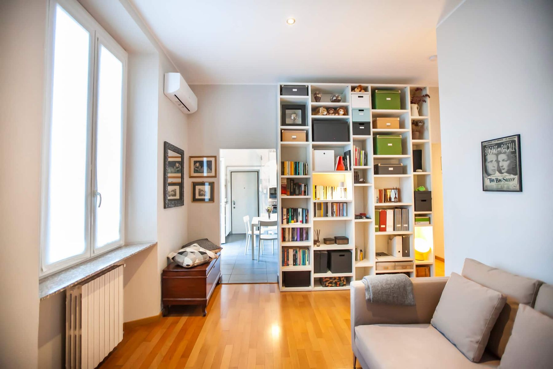 Casa Dell'Angelo — soggiorno con libreria a tutta parete e grande finestra